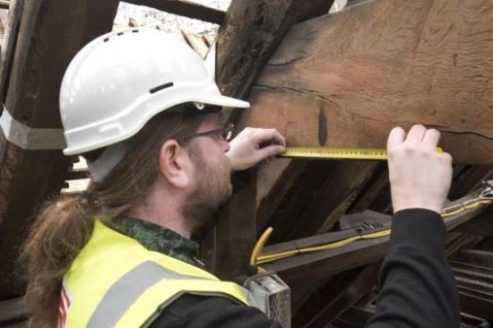 Archaeologist inspects apotropaic scorch marks at tower of london c mola