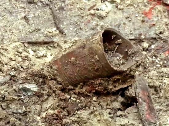 Beautifully inscribed metal object being unearthed tomb