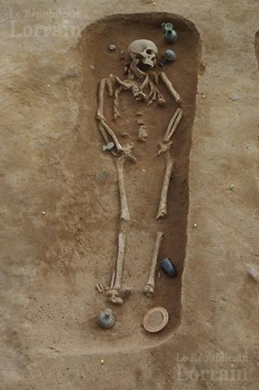 Cette photo montre la position du corps dans l une des tombes on peut voir les flacons en verre et les pots en ceramique qui l entourent photo pole archeologie preventive de metz m